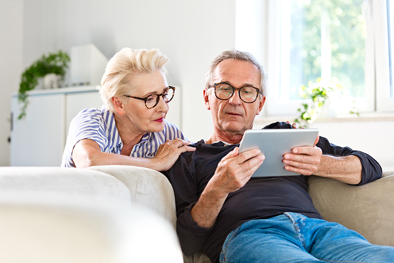 an old couple looking at a tablet