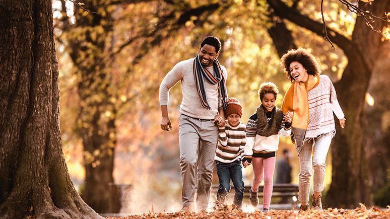 a family in front of autumn trees